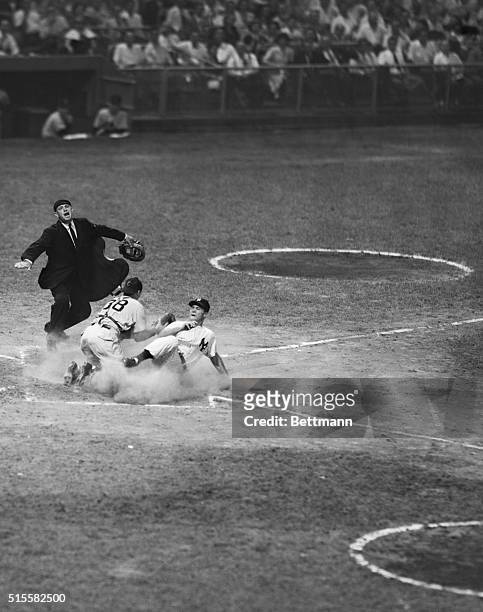 Hank Bauer of the New York Yankees slides into home plate.
