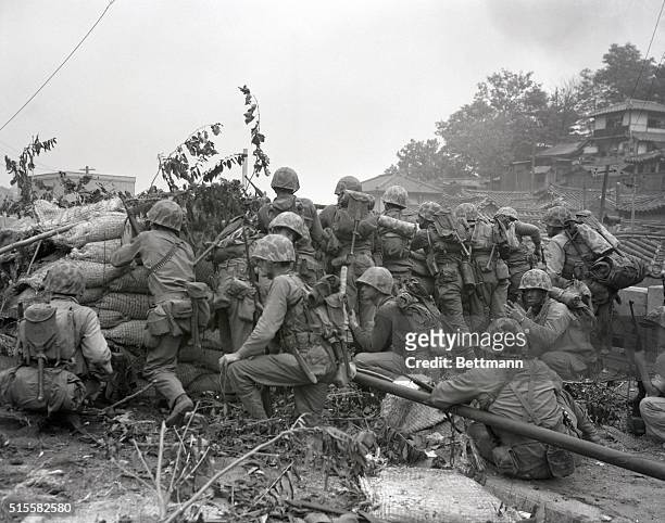 Marines take cover behind a barricade as they take fire from the North Koreans.