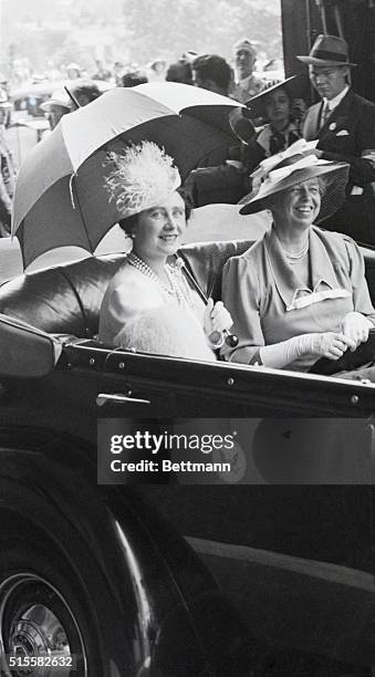 Queen Consort Elizabeth seeks refuge from the sun's rays under a parasol as her Majesty rides with Mrs. F. D. Roosevelt in the Royal Procession in...