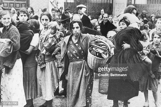 The tragedy of the Spanish Civil War is seared into the faces of these women and children, fleeing from their shattered homes in Madrid. | Location:...