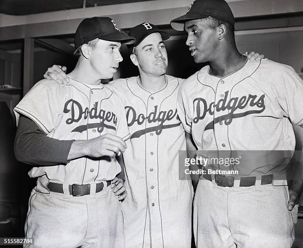Brooklyn Dodgers' teammates shortstop Pee Wee Reese, outfielder Duke Snider, and starting pitcher Joe Black console each other after a 2-0 loss to...