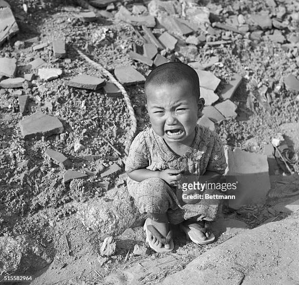 Japanese child sits crying in the rubble of Hiroshima a year after the city was devastated by the world's first atomic bomb attack, on August 6,...