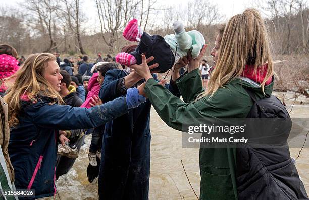 Migrants try to cross a river after leaving the Idomeni refugee camp on March 13, 2016 in Idomeni, Greece. The decision by Macedonia to close its...