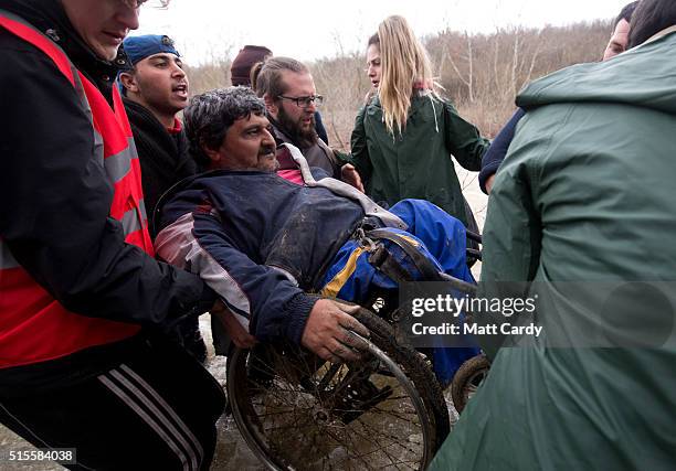 Migrants try to cross a river after leaving the Idomeni refugee camp on March 13, 2016 in Idomeni, Greece. The decision by Macedonia to close its...