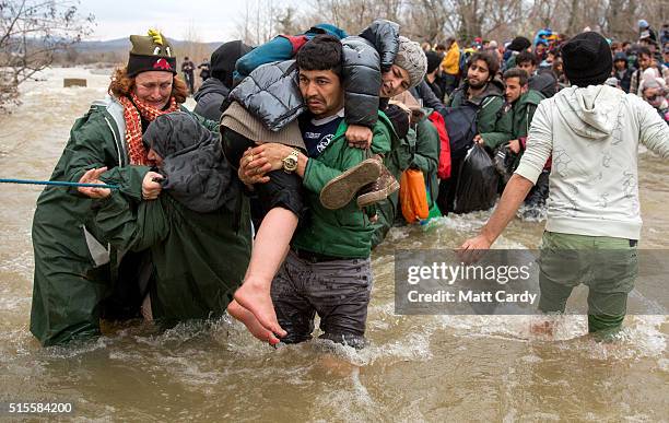 Migrants try to cross a river after leaving the Idomeni refugee camp on March 13, 2016 in Idomeni, Greece. The decision by Macedonia to close its...