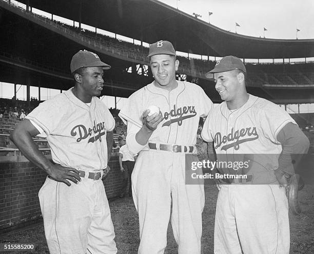 Brooklyn Dodger greats Jackie Robinson and Roy Campanella stand with new pitcher Don Newcombe at Wrigley Field. Newcombe came up to the majors this...