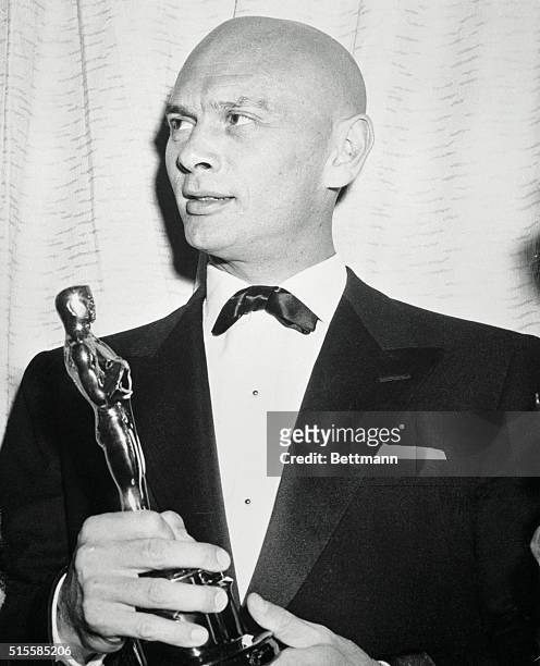 Hollywood, CA: The "smoothie" who started the whole thing, actor Yul Brynner, proudly holds the "Oscar" he won as the Best Actor of 1956 for his role...