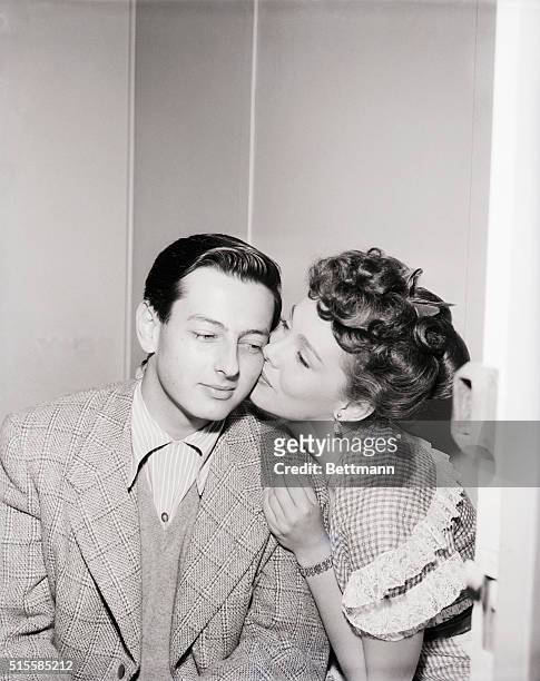 Musical composer Andre Previn gets a kiss from actress Phyllis Kirk on his 21st birthday.