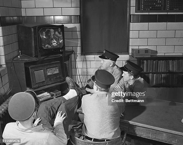 New York, NY: Firemen of Engine House No. 21 at East 40th Street are grouped around a television set as former Mayor William O'Dwyer testifies before...