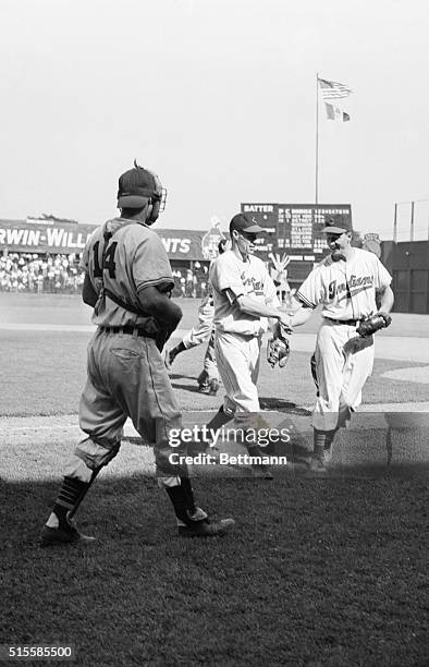 Cleveland, OH: Strikeout king Bobby Feller is congratulated by teammate Heniz Becker after hurling a 4-1 one-hitter against the Red Sox, his 20th...