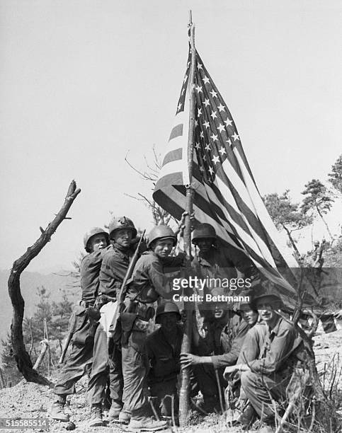 Korea: A scene reminiscent of the famed photo of the American Flag being planted atop a hard won height on Iwo Jima in World War II, is this picture...