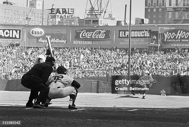 New York, NY: Yankee Jim Bouton delivers the opening pitch of the World Series' third game to Curt Flood of the Cardinals. The catcher is Elston...