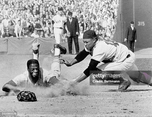 Boston, MA: Lou Brock of the Cardinals dives safely into home plate in the third inning of the sixth World Series game as Red Sox catcher Elston...