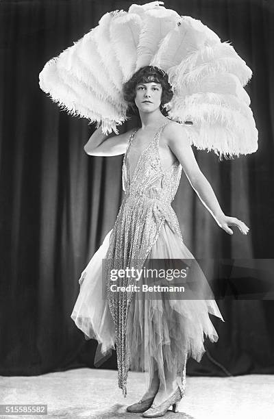 Smart Fashion from London. An evening frock of lilac tulle with a beaded tunic. The great feather fan enhances a charming evening costume.