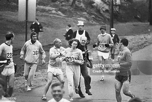 Trainer Jock Semple -- in street clothes -- enters the field of runners to try to pull Kathy Switzer out of the race. Male runners move in to form a...