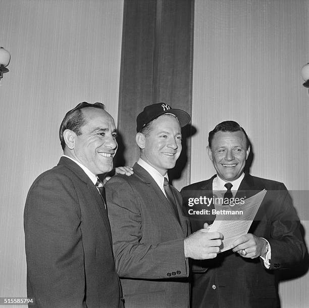 New York, NY: Yankee stars Yogi Berra, Whitey Ford and Ralph Houk check the new contract Nov. 15 at the conclusion of negotiations for the 1964...