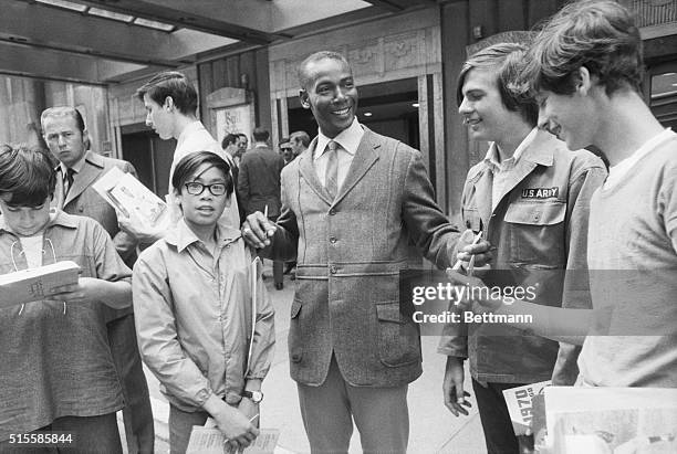 Chicago Cubs' star infielder Ernie Banks signs autographs for youngsters at the Waldorf-Astoria Hotel in New York City. He is in town with the Cubs...