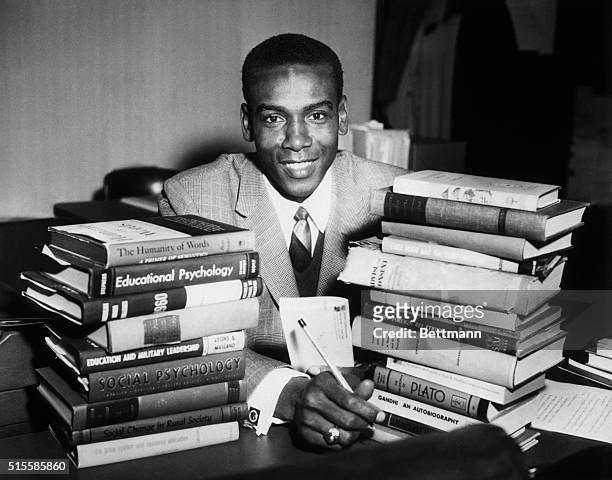 Textbooks surround Chicago Cubs star shortstop Ernie Banks as he attends class at the University of Chicago where he is taking night courses in...