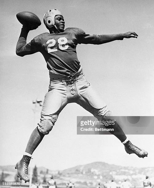Quarterback Jackie Robinson, the college's first student-athlete to earn varsity letters in four different sports, leaps in the air to throw a pass....