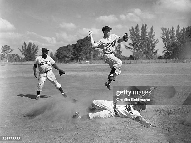 Jackie Robiinson and Pee Wee Reese demonstrate the double play combination.