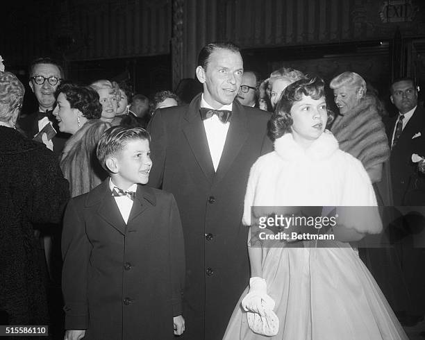 Portrait of singer/actor Frank Sinatra standing with his children Nancy and Frank, Jr., 10.