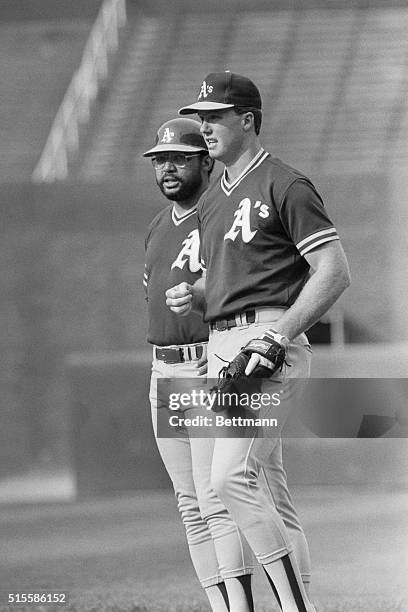 Chicago, IL: Athletics' veteran Reggie Jackson gives advice to rookie sensation Mark McGwire prior to game at Comiskey Park. McGwire has hit 27...