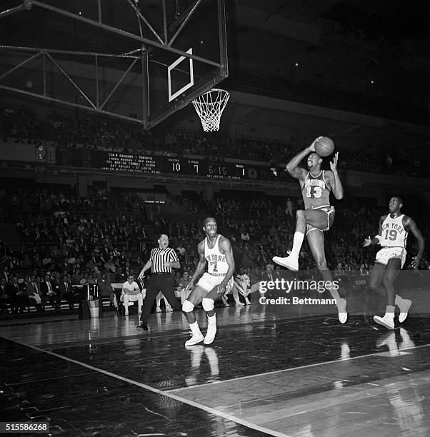 Wilt Chamberlain of the San Francisco Warriors flies to the basket to score two points against the New York Knicks at Madison Square Garden. At right...