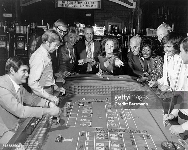 Las Vegas,NV: Picture shows people gambling in a Las Vegas casino. A woman is shown throwing the dice at a craps table with people watching. Undated...
