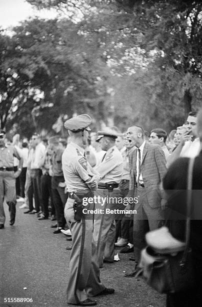 Mississippi state troopers stand guard as a University of Mississippi student shouts insults at U. S. Marshals surrounding the University's...