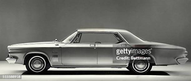 Picture shows a full length shot of a Chrysler automobile. It is a four door model with chrome outline and white wall tires.