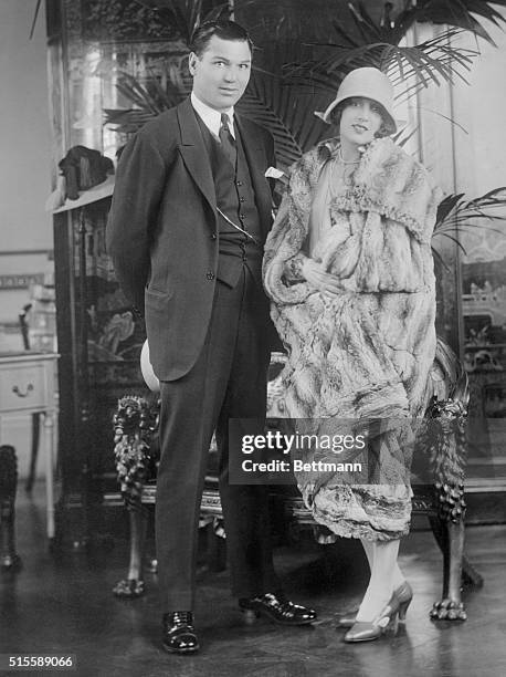 Mr. And Mrs. Jack Dempsey, , is shown here, with her wearing a magnificent ne Chinchilla Cloak especially created by Mr. Reville, the dressmaker to...