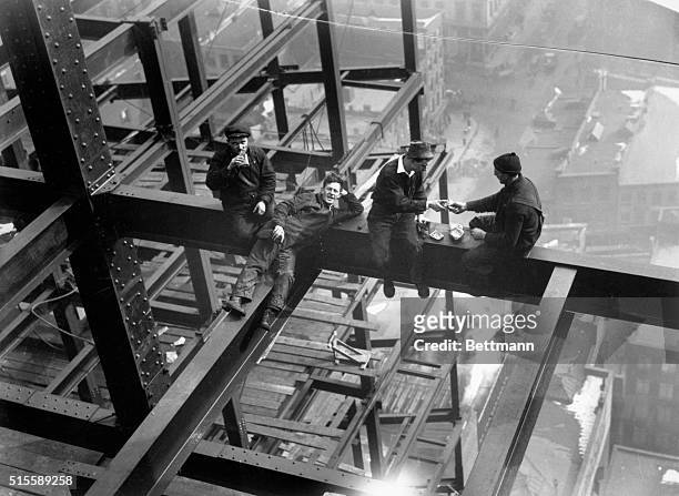 New York: The new telephone company skyscraper at Vesey Street and the North River under construction. Photo shows the iron workers perched on a...