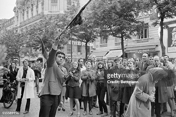 Paris, France- As friends applaud, a demonstrator holds up a burning red flag during a demonstration of the "Occident Movement" on the Blv des...