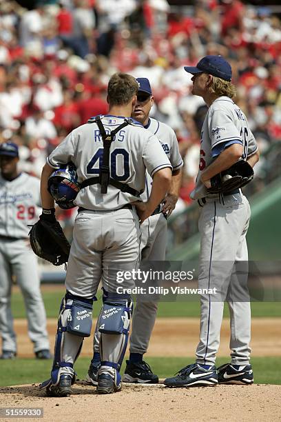 Pitcher Jeff Weaver, catcher David Ross and pitching coach Jim Colborn of the Los Angeles Dodgers meet on the mound during the game against the St....