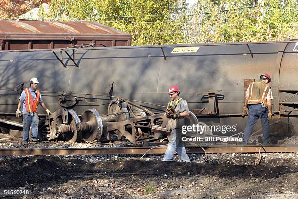 Workers clean up a seven-car Canadian National Railway train derailment October 25, 2004 in Detroit, Michigan. The derailment was declared a level 3...