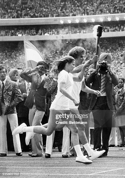 Montreal, Canada- Canadian teenagers Sandra Anderson and Stephen Prefontaine jointly carry the Olympic Flame into Olympic Stadium, where they passed...