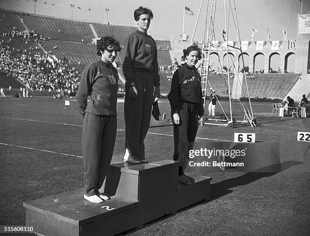 Eighty meter hurdles' winner's podium. Left to right: Evelyn Hall of U.S., second; Babe Didrikson, of U.S., first; Marjorie Clark, of South Africa,...