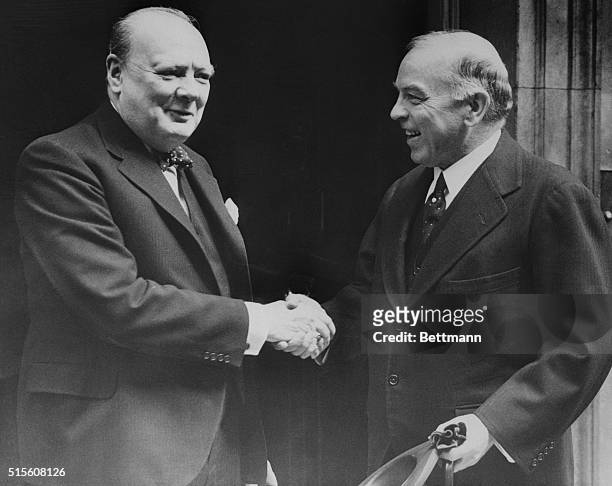 Premier Greets Premier. London, England: Prime Minister Winston Churchill greets Mackenzie King, Canadian premier, in the doorway of 10 Downing...