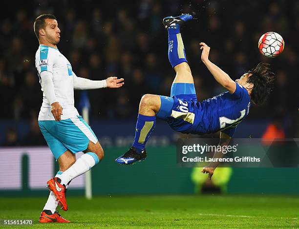 Shinji Okazaki of Leicester City scores their first goal with an overhead kick as Steven Taylor of Newcastle United looks on during the Barclays...