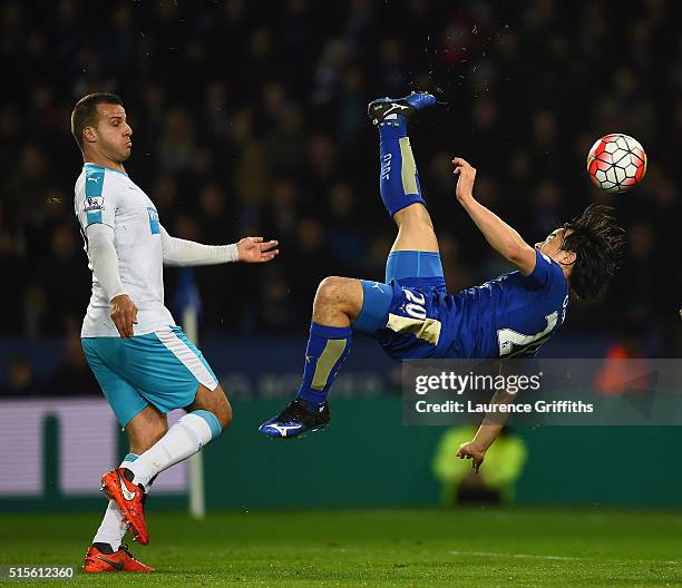 Shinji Okazaki of Leicester City scores their first goal with an overhead kick as Steven Taylor of Newcastle United looks on during the Barclays...