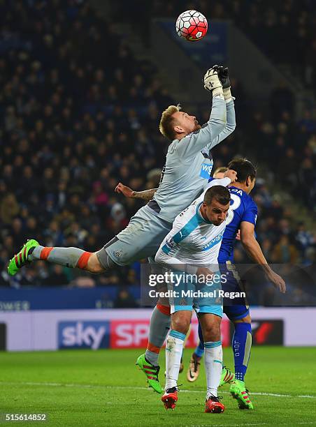 Goalkeeper Robert Elliot of Newcastle United attempts to claim the ball above Steven Taylor of Newcastle United and Leonardo Ulloa of Leicester City...