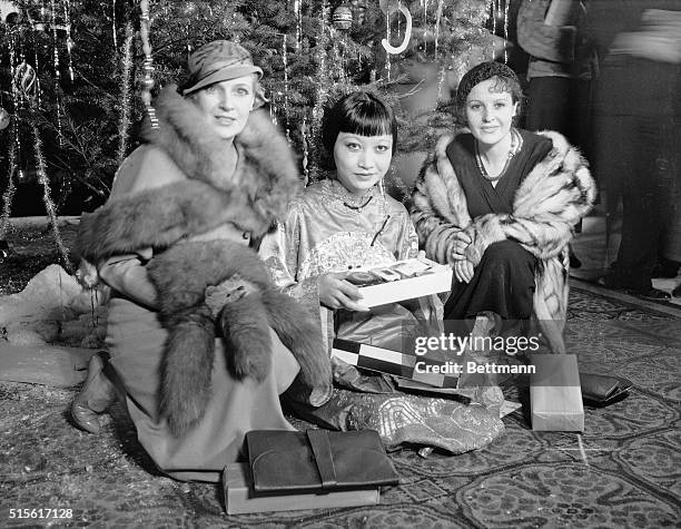 Hollywood, CA: Left to right: Mara Alba, Anna May Wong and Alga Baclanova kneel with their presents during a Christmas Party given by the Foreign...