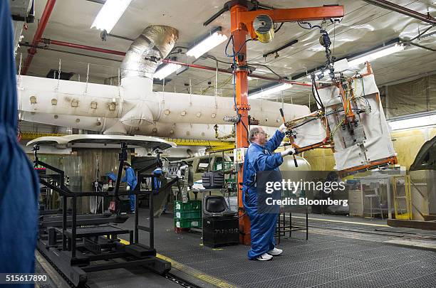 An employee transfers a piece of sheet metal during production at the General Motors Co. Assembly plant in Arlington, Texas, U.S., on Thursday, March...