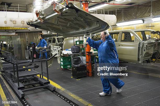 An employee transfers a piece of sheet metal during production at the General Motors Co. Assembly plant in Arlington, Texas, U.S., on Thursday, March...