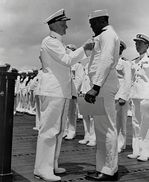 Admiral Chester W. Nimitz pins the Navy Cross on Doris 'Dorie' Miller, the first Negro to win the award, in ceremony aboard a warship at Pearl Harbor.