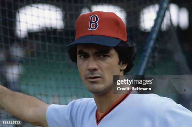 Close-up of Red Sox outfielder, Dwight Evans, leaning against the fowl ball fence with one hand.