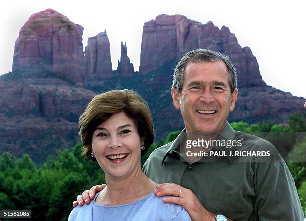 Texas Governor and Republican party nominee George W. Bush and his wife Laura pose for a photo at Red Rock Crossing as "Cathedral Rock" looms to the...