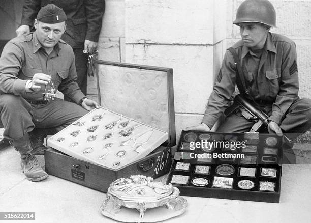 Yanks of the 7th Army unearth looted art treasures hidden by the Nazis. Here is a tray of valuable antique jewelry and a tray of ornaments, snuff...
