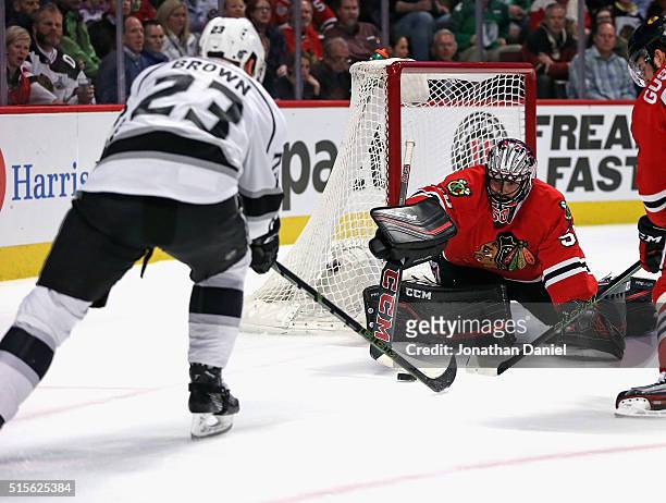 Corey Crawford of the Chicago Blackhawks makes a save against Dustin Brown of the Los Angeles Kings at the United Center on March 14, 2016 in...