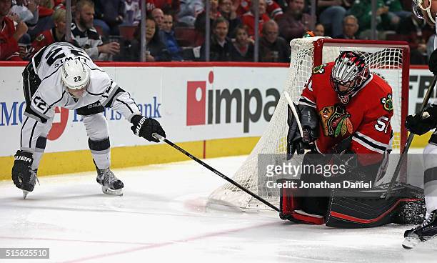 Trevor Lewis of the Los Angeles Kings gets his stick caught as Corey Crawford of the Chicago Blackhawks makes a save on his shot at the United Center...